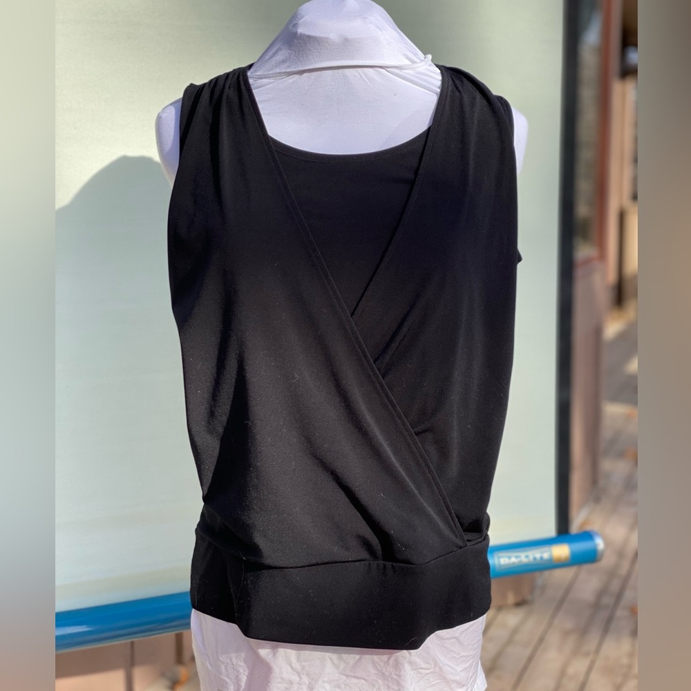 Chico’s brand size 1. Faux wrap, sleeveless top. Black. Wide band at hem.